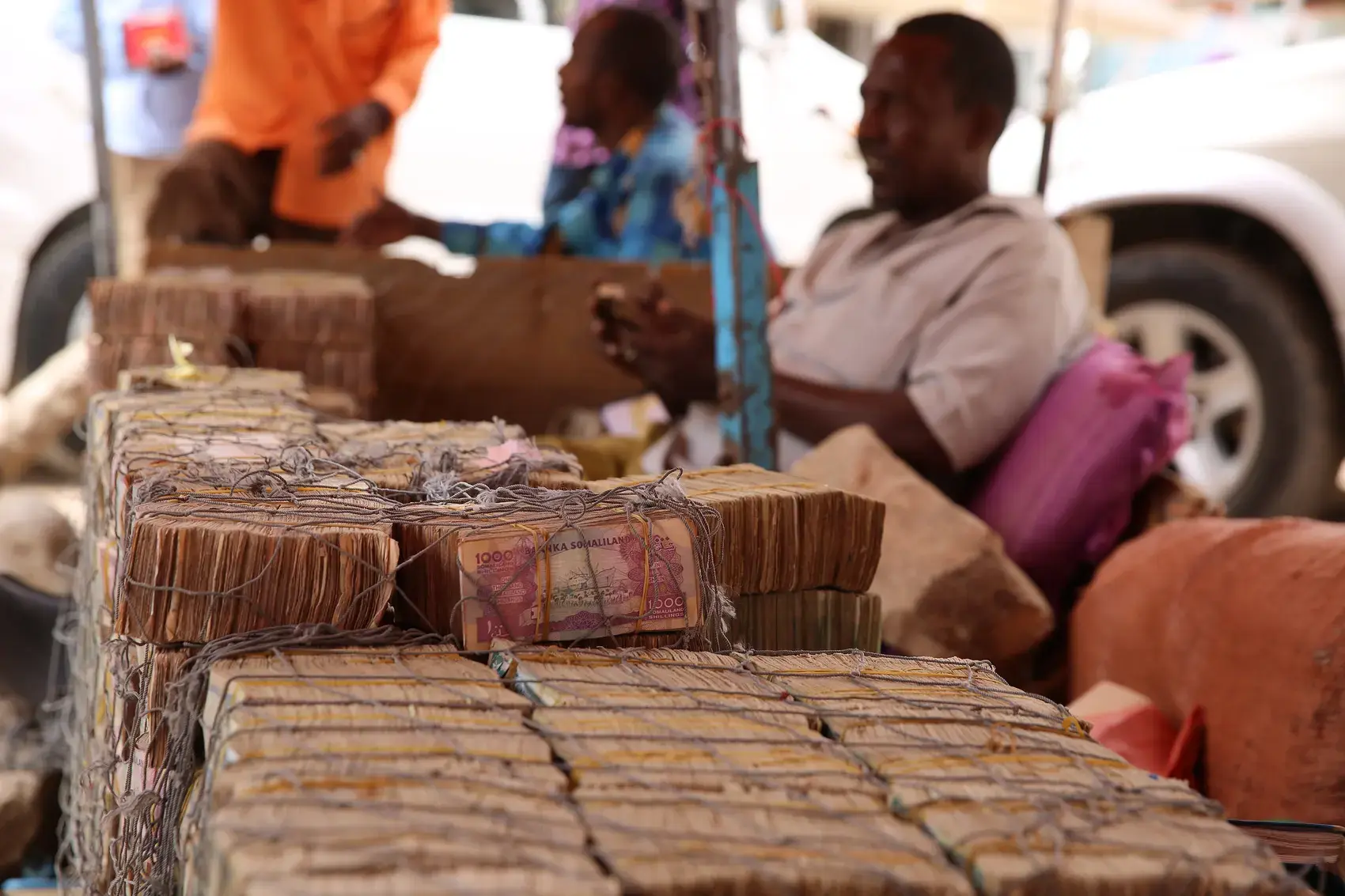 Money changers with stacks of banknotes at a market in Hargeisa