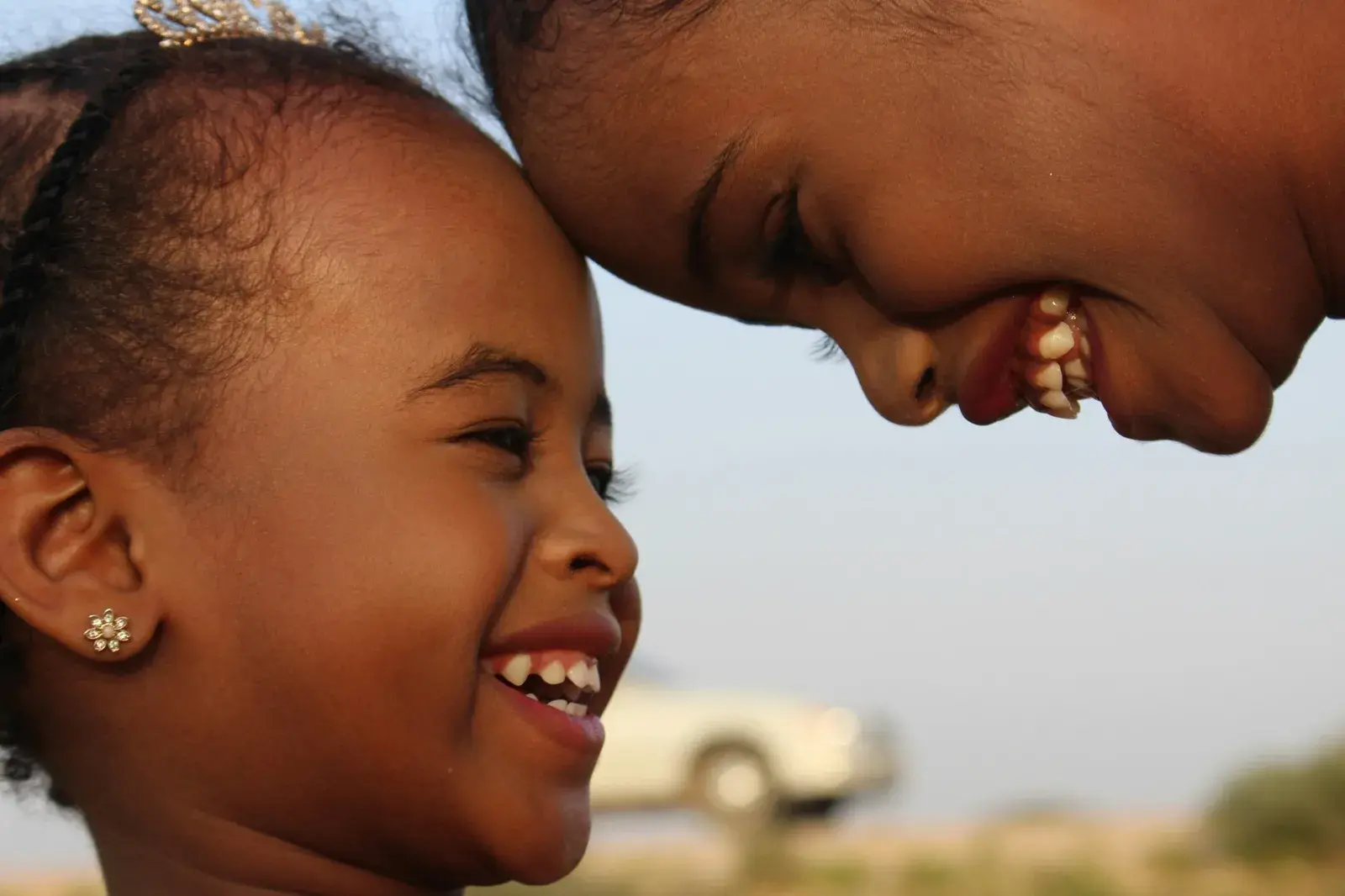 Two children laughing with their foreheads touching