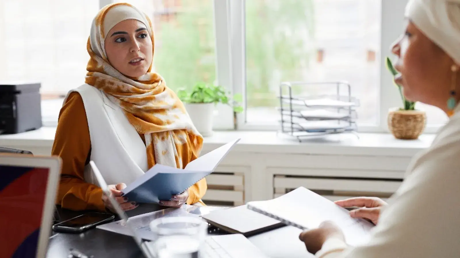 Two professionals reviewing documents during a consultation meeting